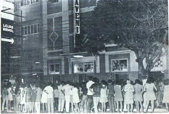 Foto em preto e branco de pessoas na frente de um prédio

Descrição gerada automaticamente
