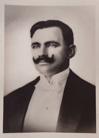 Foto preta e branca de homem de terno e gravata

Descrição gerada automaticamente