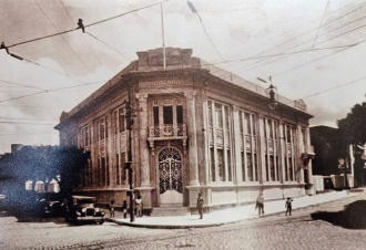 Foto em preto e branco de rua com prédios ao fundo Descrição gerada automaticamente