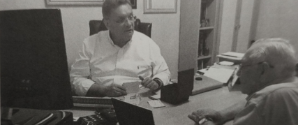 Foto preta e branca de homem sentado em frente a computador O conteúdo gerado por IA pode estar incorreto.