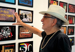 Sergio Vieira Cardoso, de chapéu e óculos, apresenta obras em uma exposição